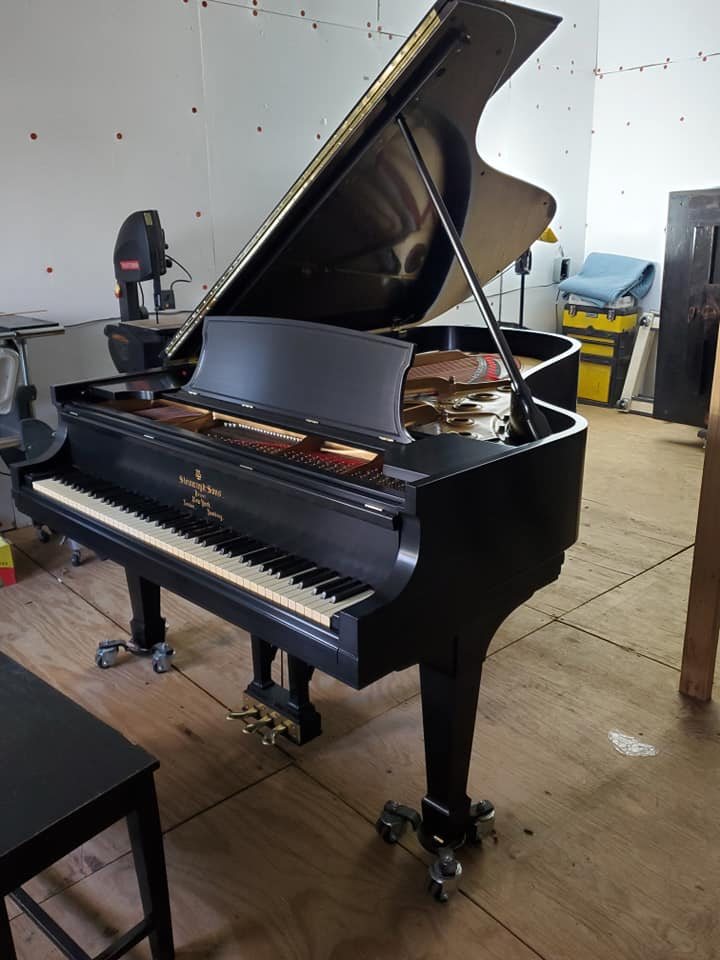 A Steinway grand piano in Brandon Carter's workshop with the action removed